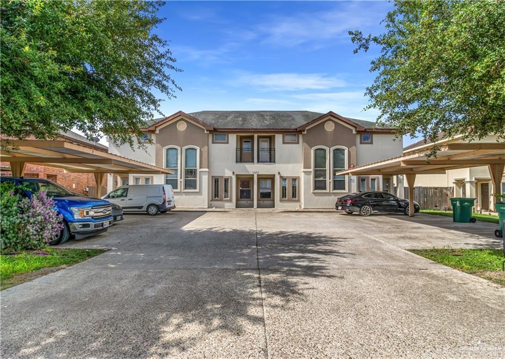 a front view of a house with a yard and car parked