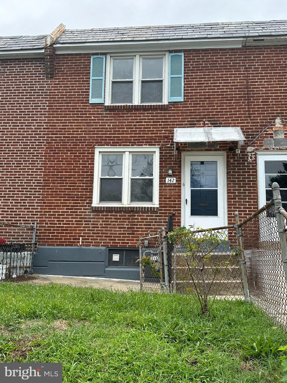 a brick house with a small yard and a large window