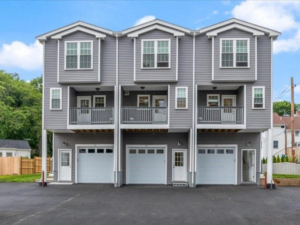 a front view of a house with a yard and parking space