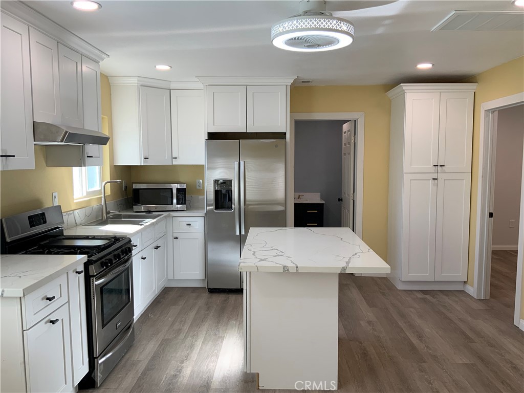 a kitchen with stainless steel appliances a stove refrigerator sink and cabinets