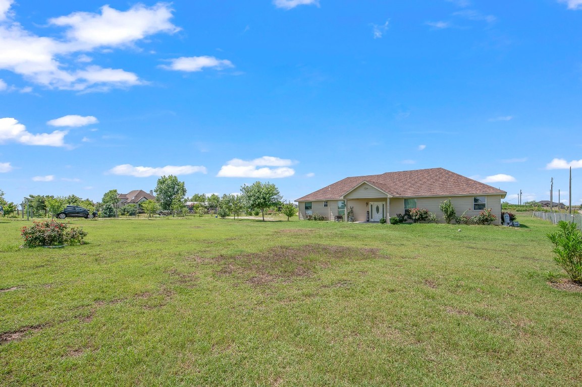 a view of a green field with an house in the background