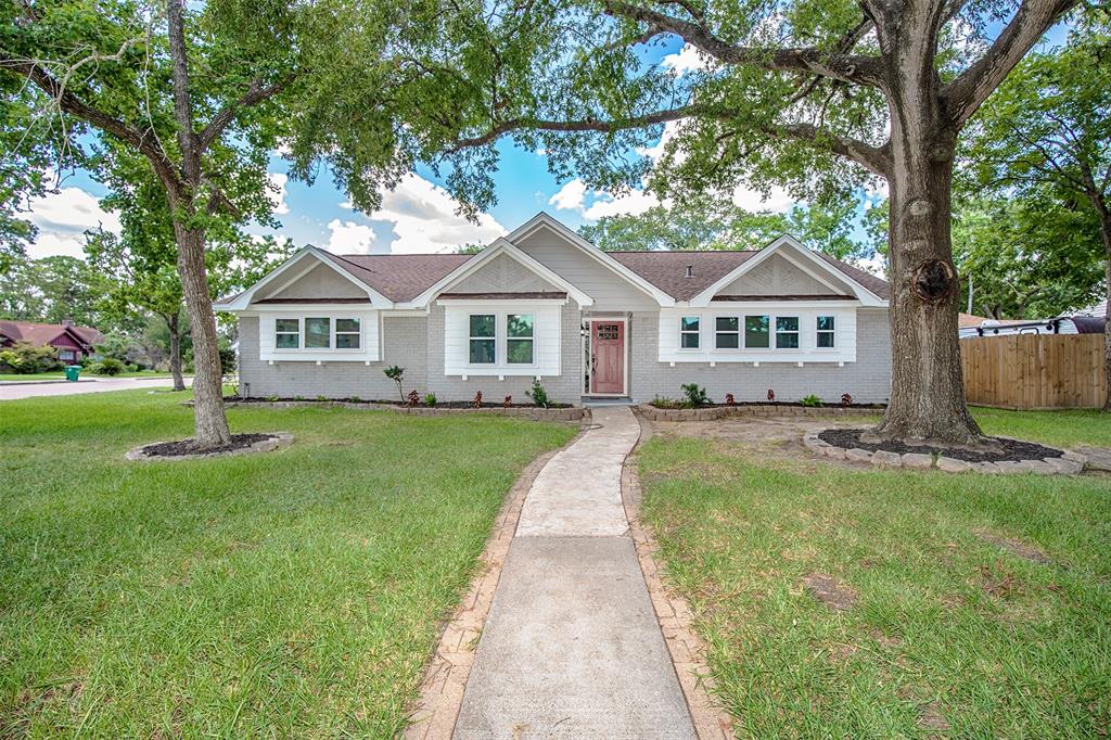 a front view of a house with a yard and trees