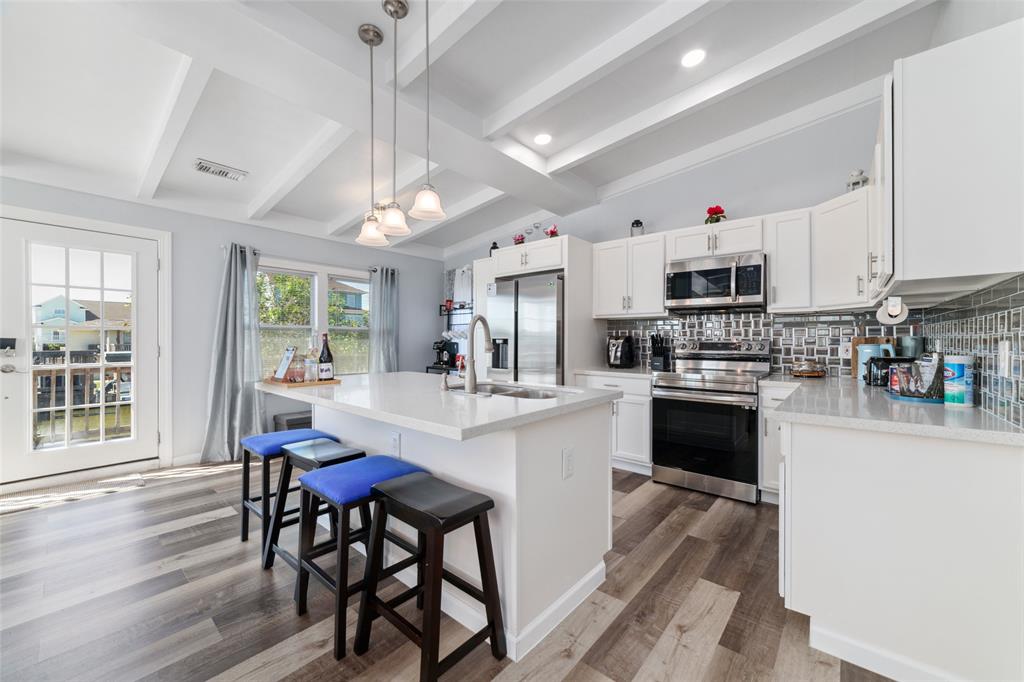 a kitchen with stainless steel appliances a white table and chairs in it