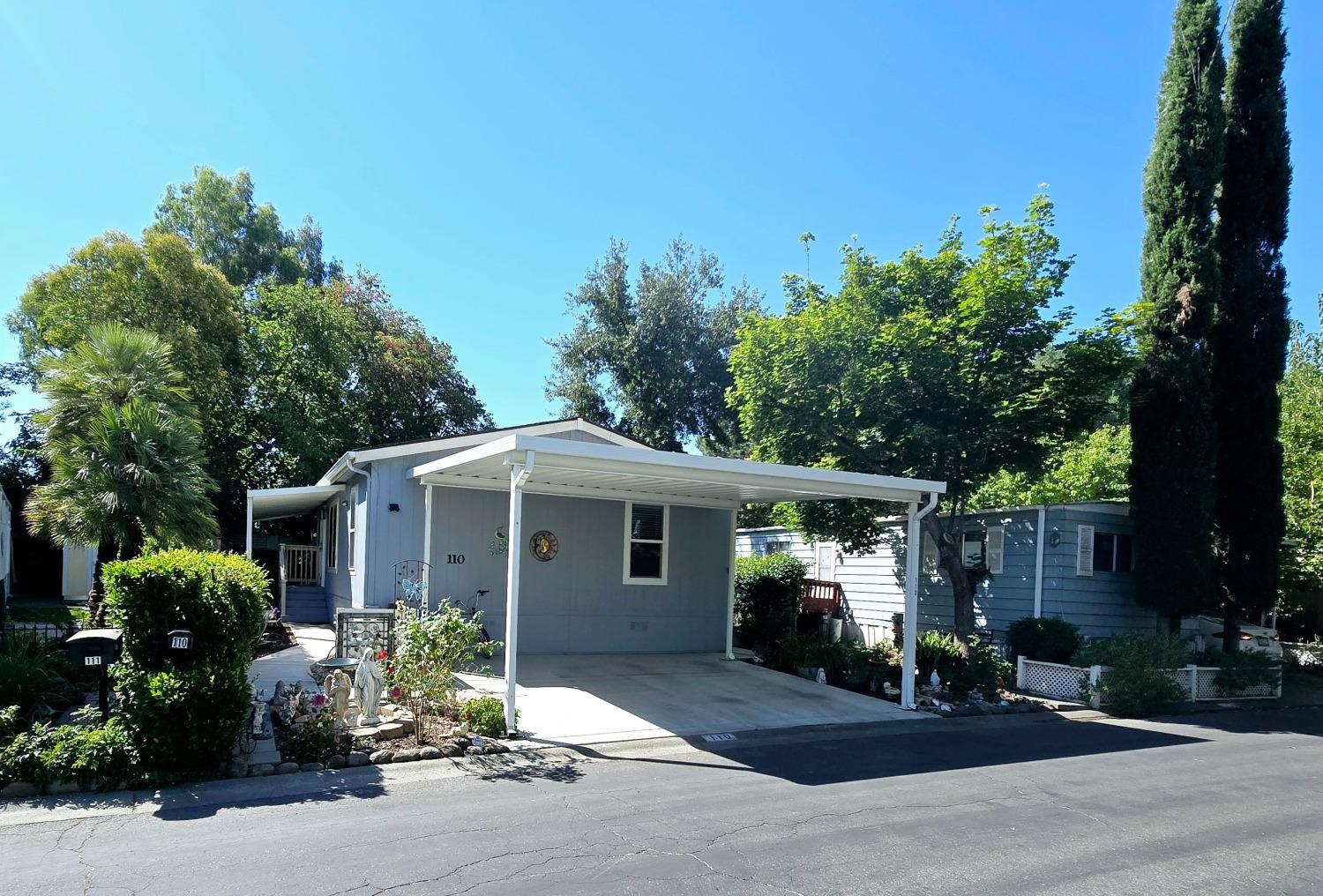 a front view of a house with a yard and potted plants