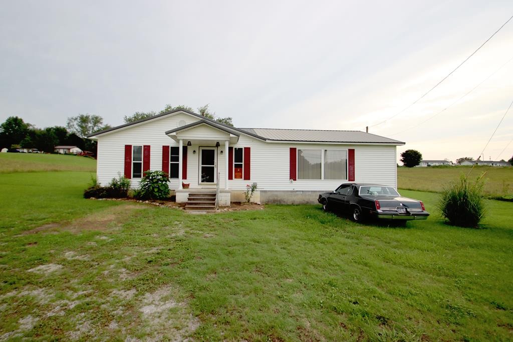 a front view of a house with a garden and yard