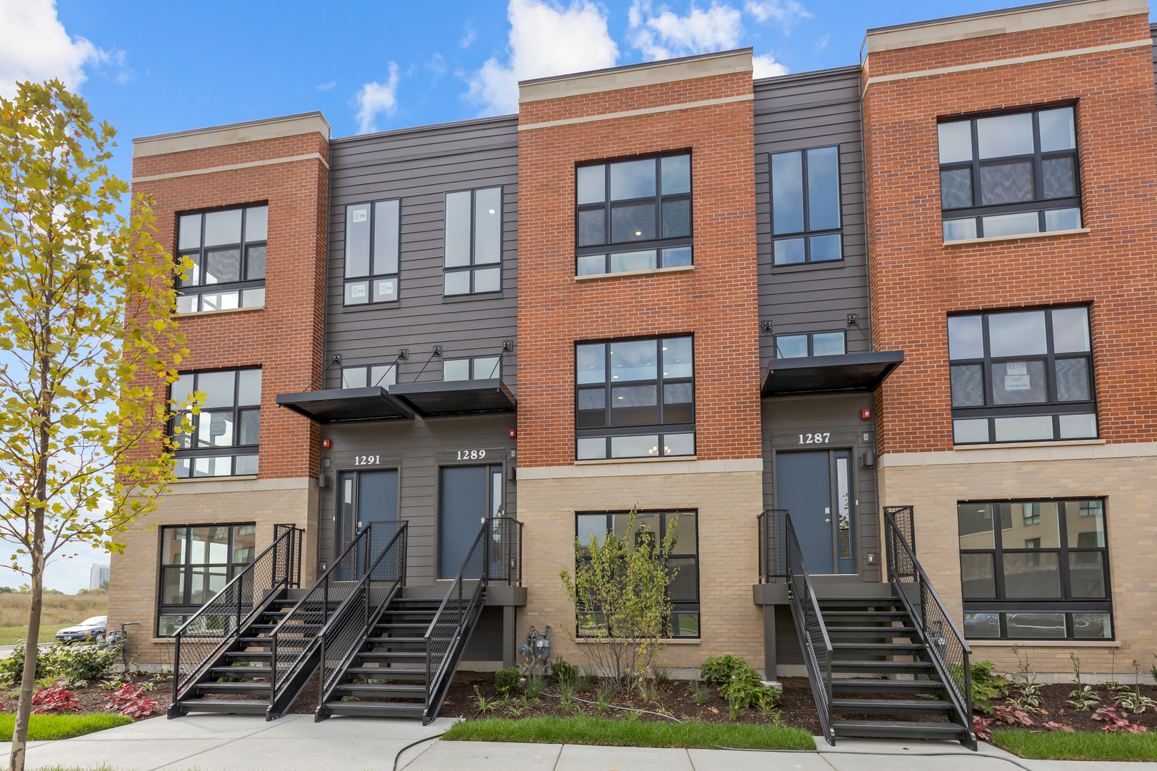 a front view of a residential apartment building with a yard