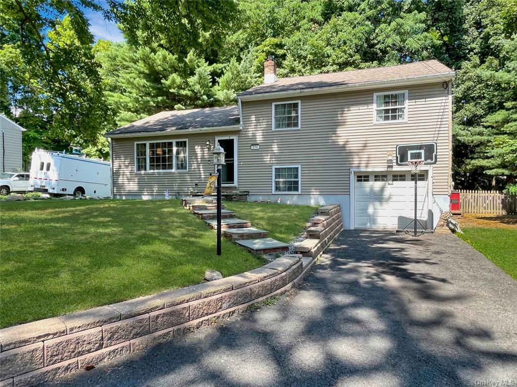 View of front of house with a front yard and a garage