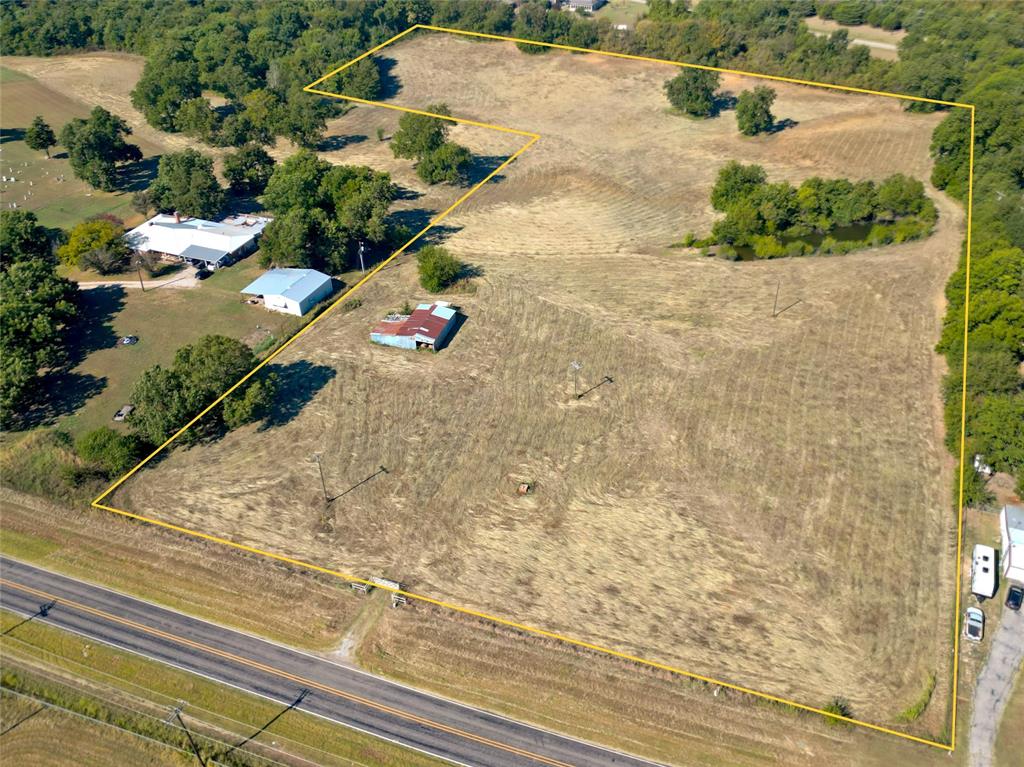 an aerial view of a house with a yard and covered with trees