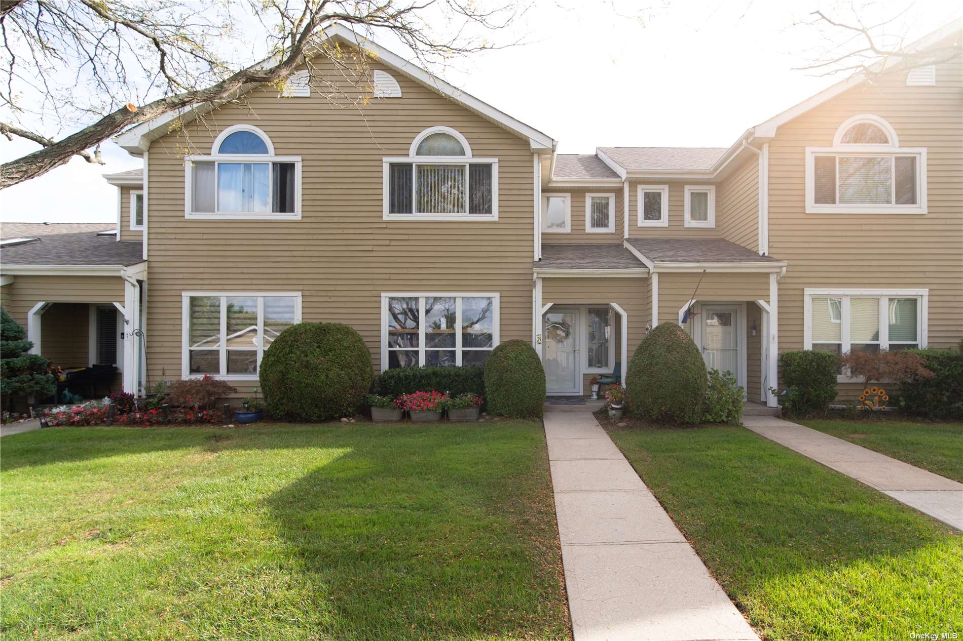 a front view of a house with a garden and yard