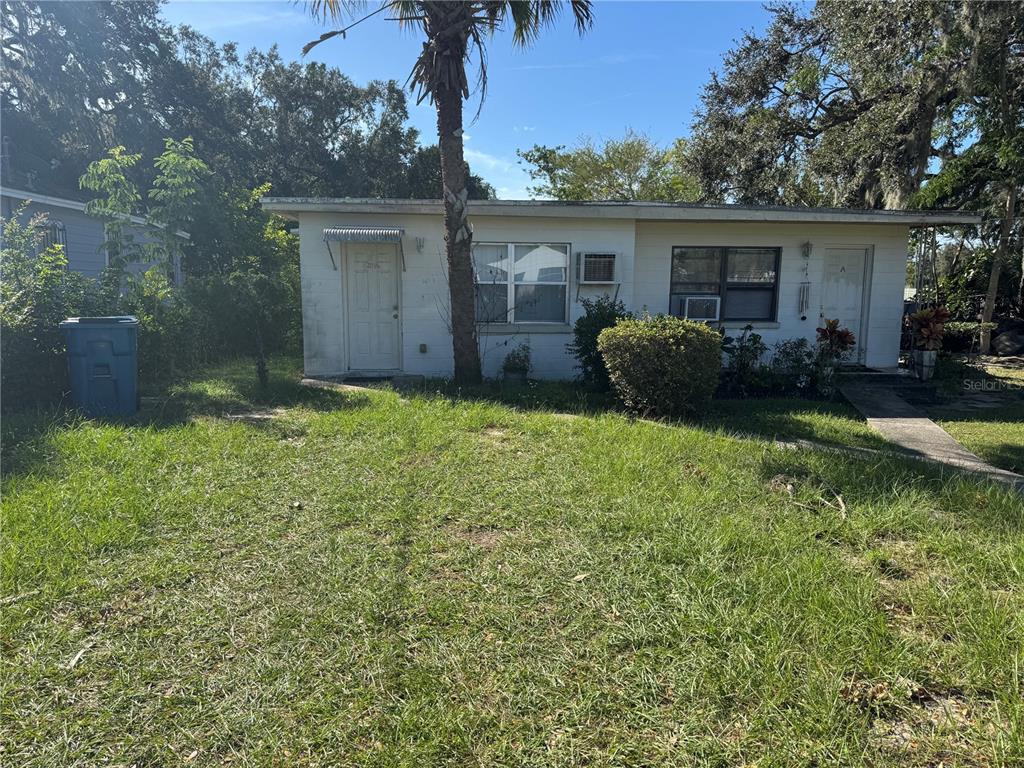 front view of a house with yard and a tree