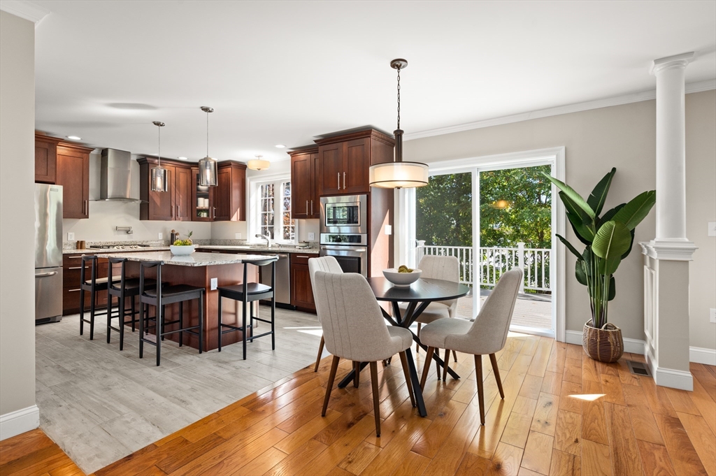 a view of a dining room and livingroom with furniture wooden floor a chandelier