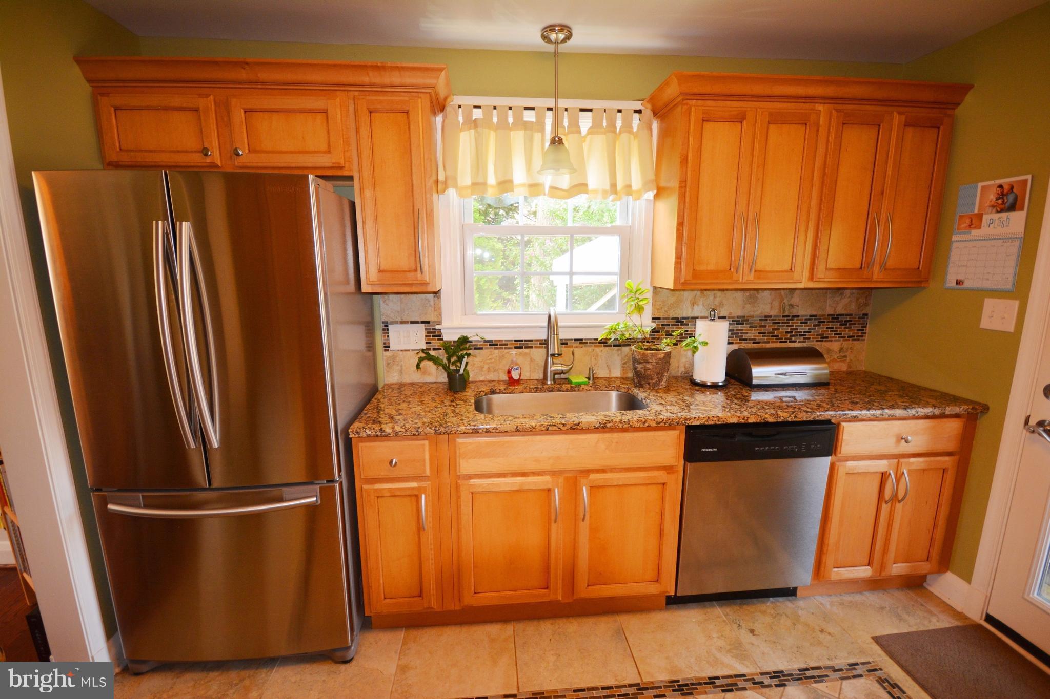 a kitchen with stainless steel appliances a refrigerator sink and cabinets