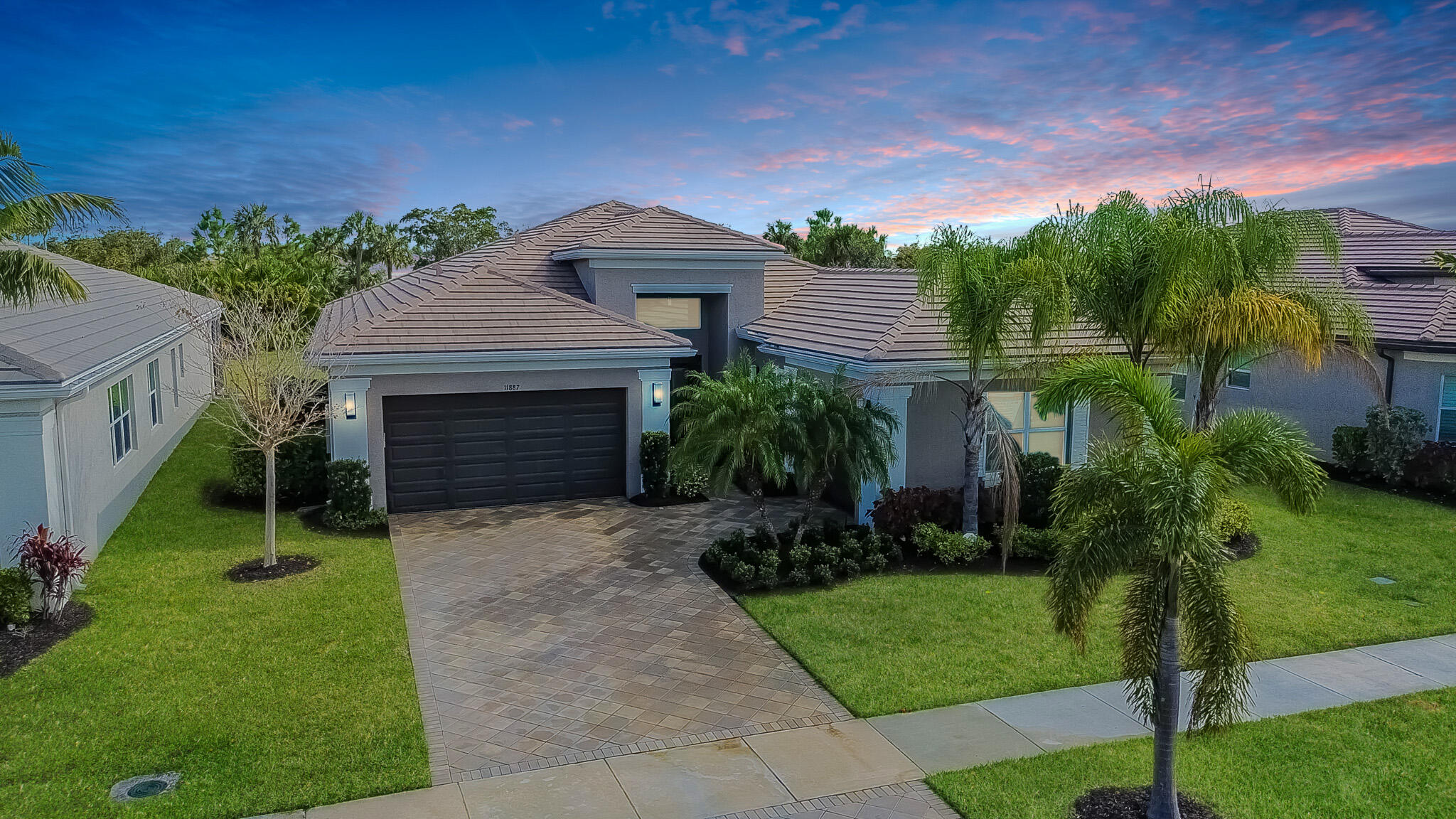 a front view of a house with a yard and trees