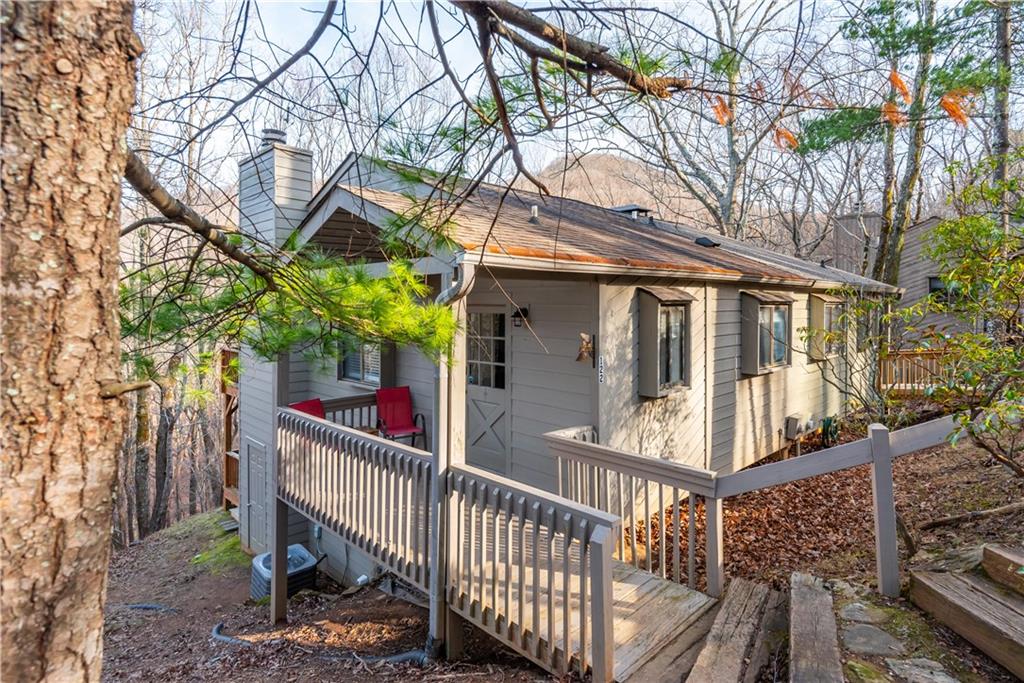 a view of a house with a tree and wooden fence