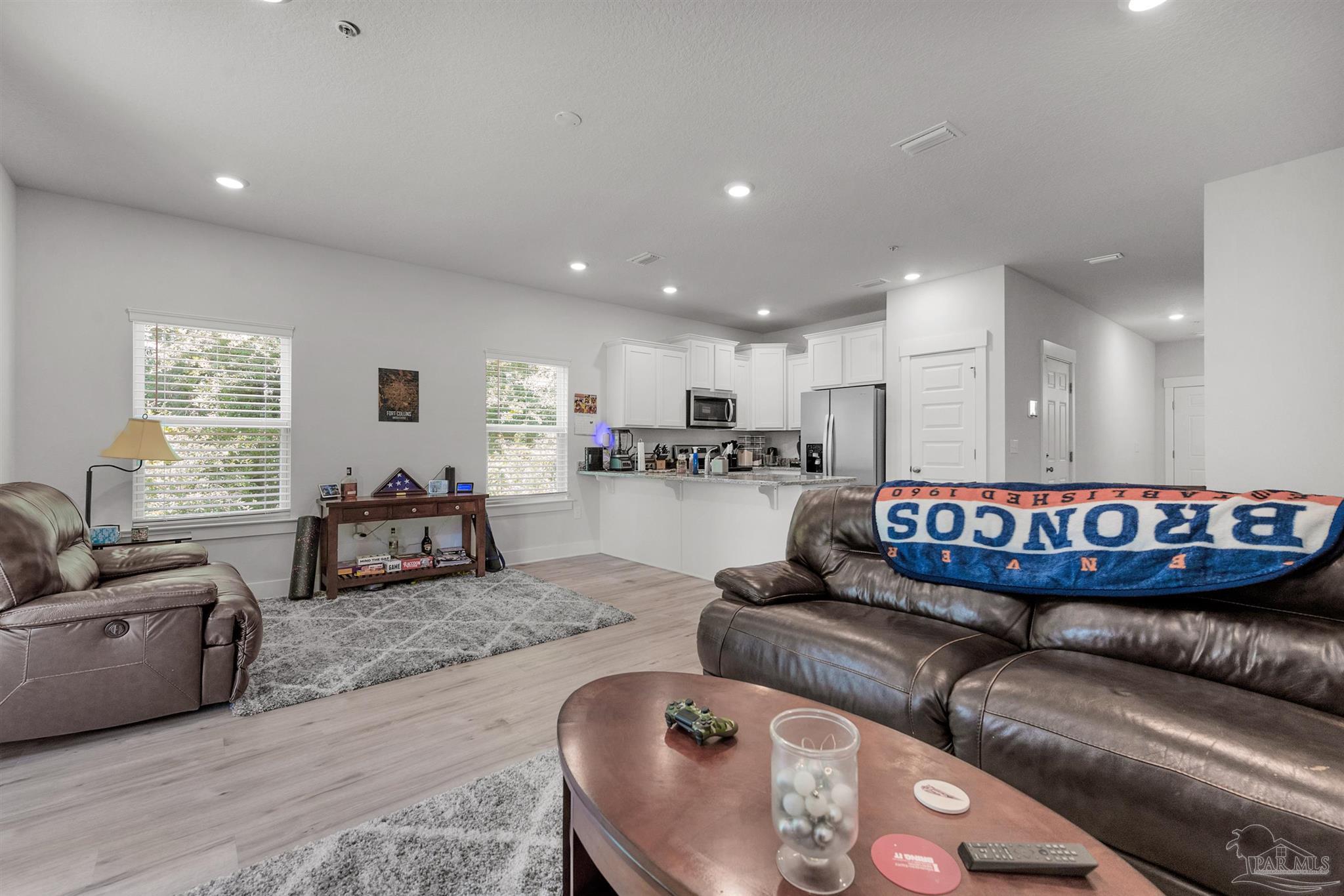 a living room with furniture and kitchen view