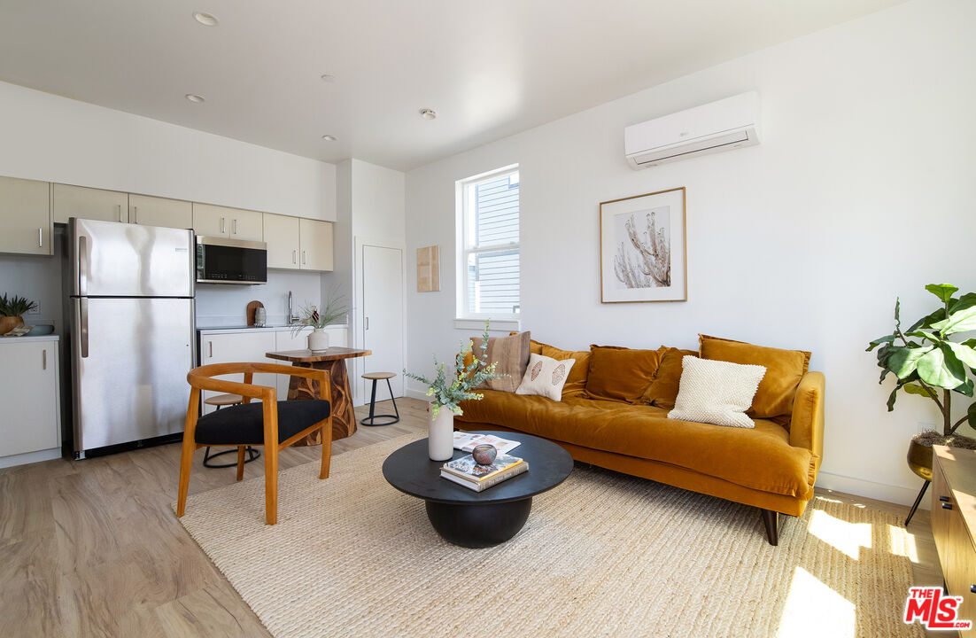 a living room with furniture and a dining table with wooden floor