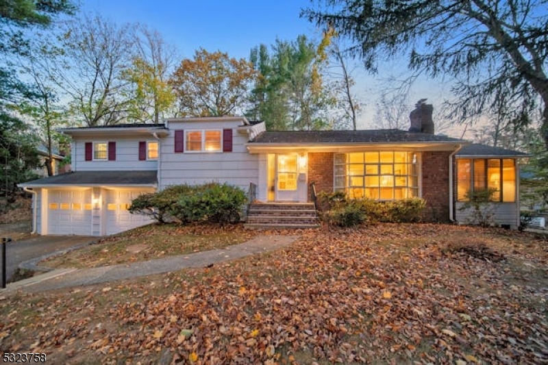 a view of a house with a large tree and a yard