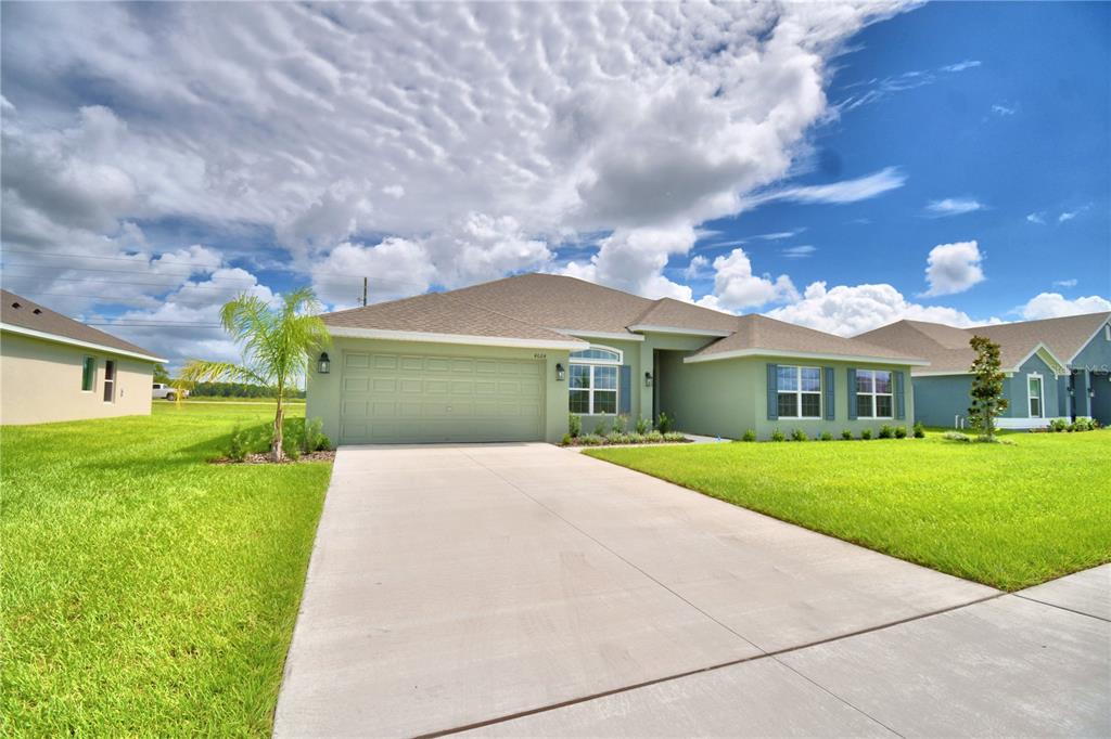 a front view of a house with a yard and garage