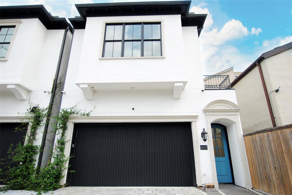 a front view of a house with white walls and stairs