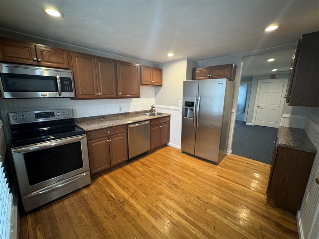 a kitchen with stainless steel appliances granite countertop a stove a sink and a refrigerator