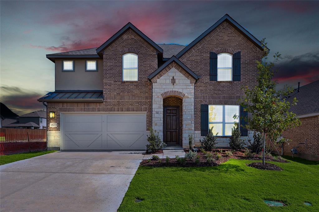 a front view of a house with a yard and garage