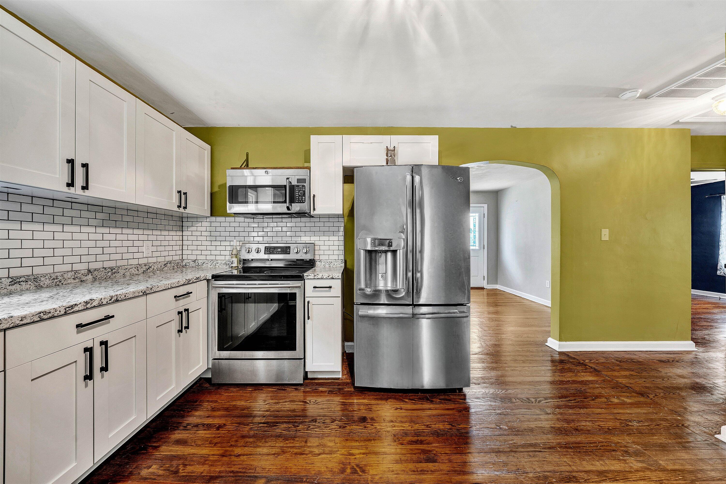 a kitchen with granite countertop a refrigerator and a sink