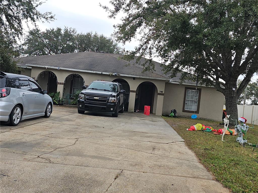 a front view of a house with cars parked