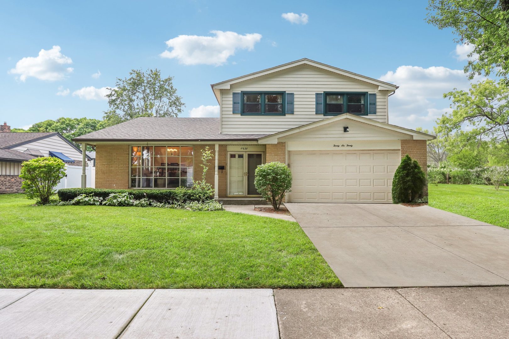 a front view of a house with a yard and trees