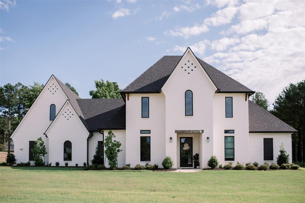 a view of a white house next to a yard