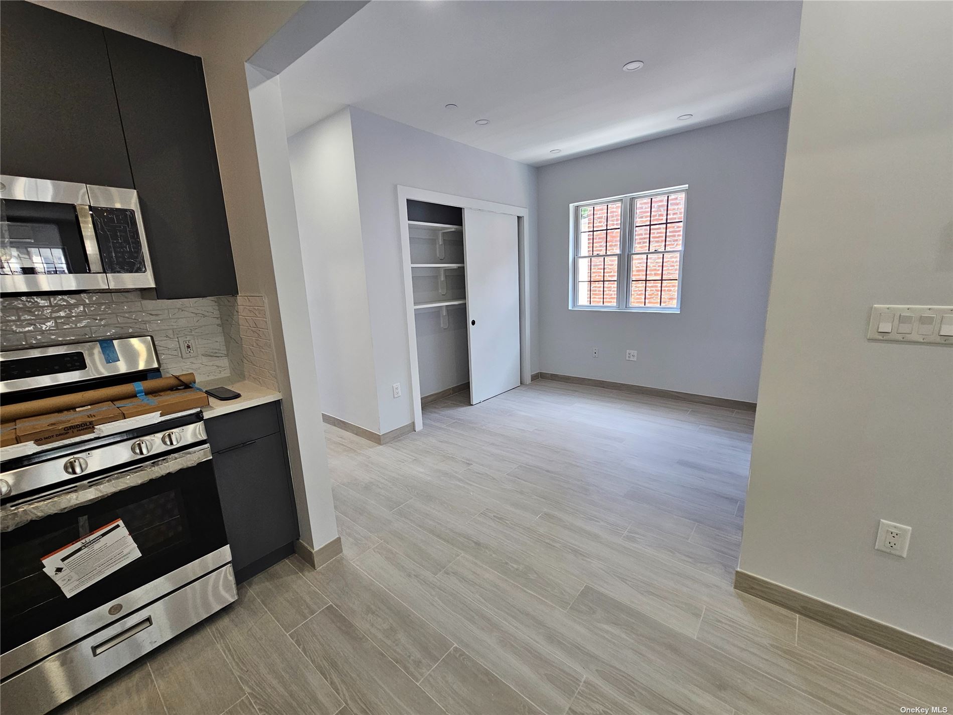 a view of kitchen with wooden floor electronic appliances and windows