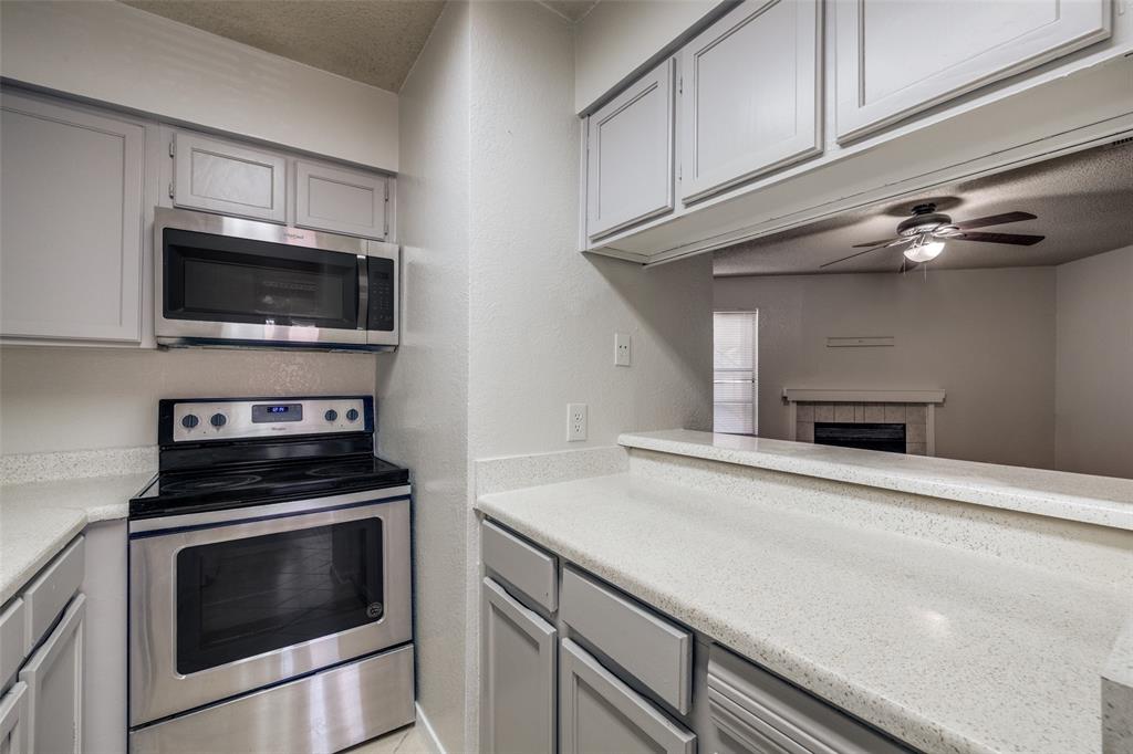 a kitchen with granite countertop cabinets stainless steel appliances and wooden floor