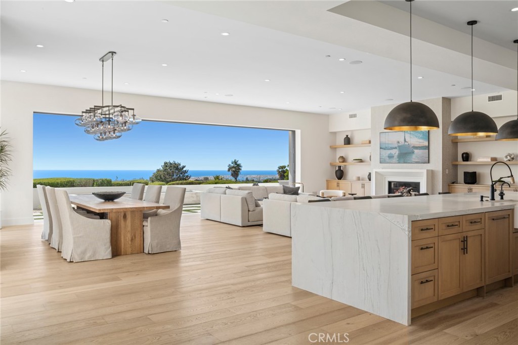 a kitchen with stainless steel appliances kitchen island a large island in the center and a wooden floor