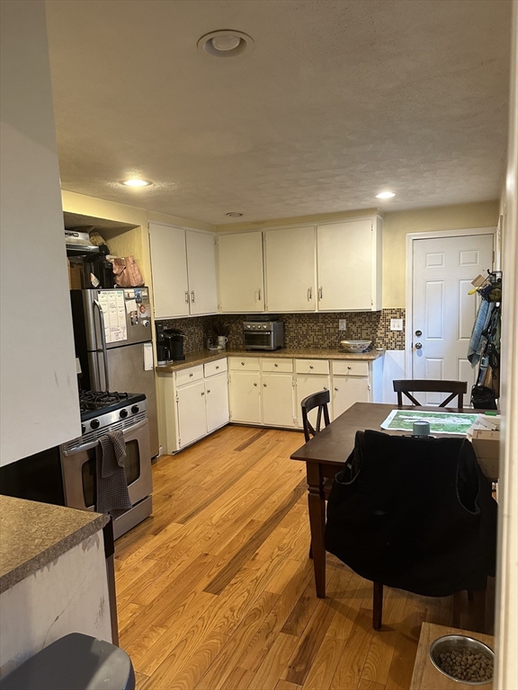 a kitchen with stainless steel appliances kitchen island granite countertop a refrigerator and a stove top oven