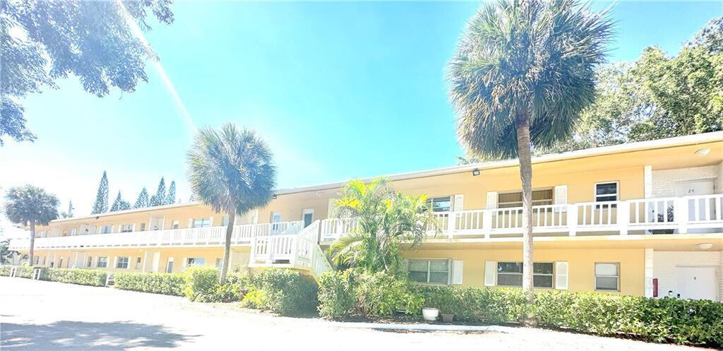 a front view of a building with palm trees