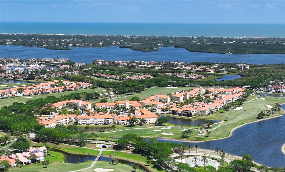 an aerial view of a city with lots of residential buildings ocean and mountain view in back