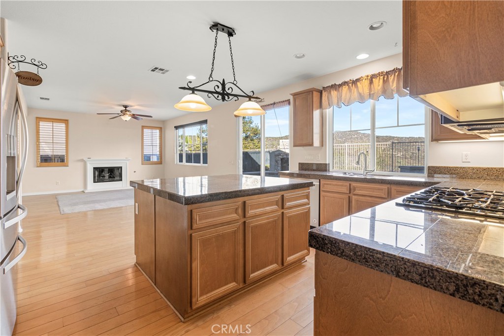 a kitchen with stainless steel appliances granite countertop a sink a stove and a wooden floors