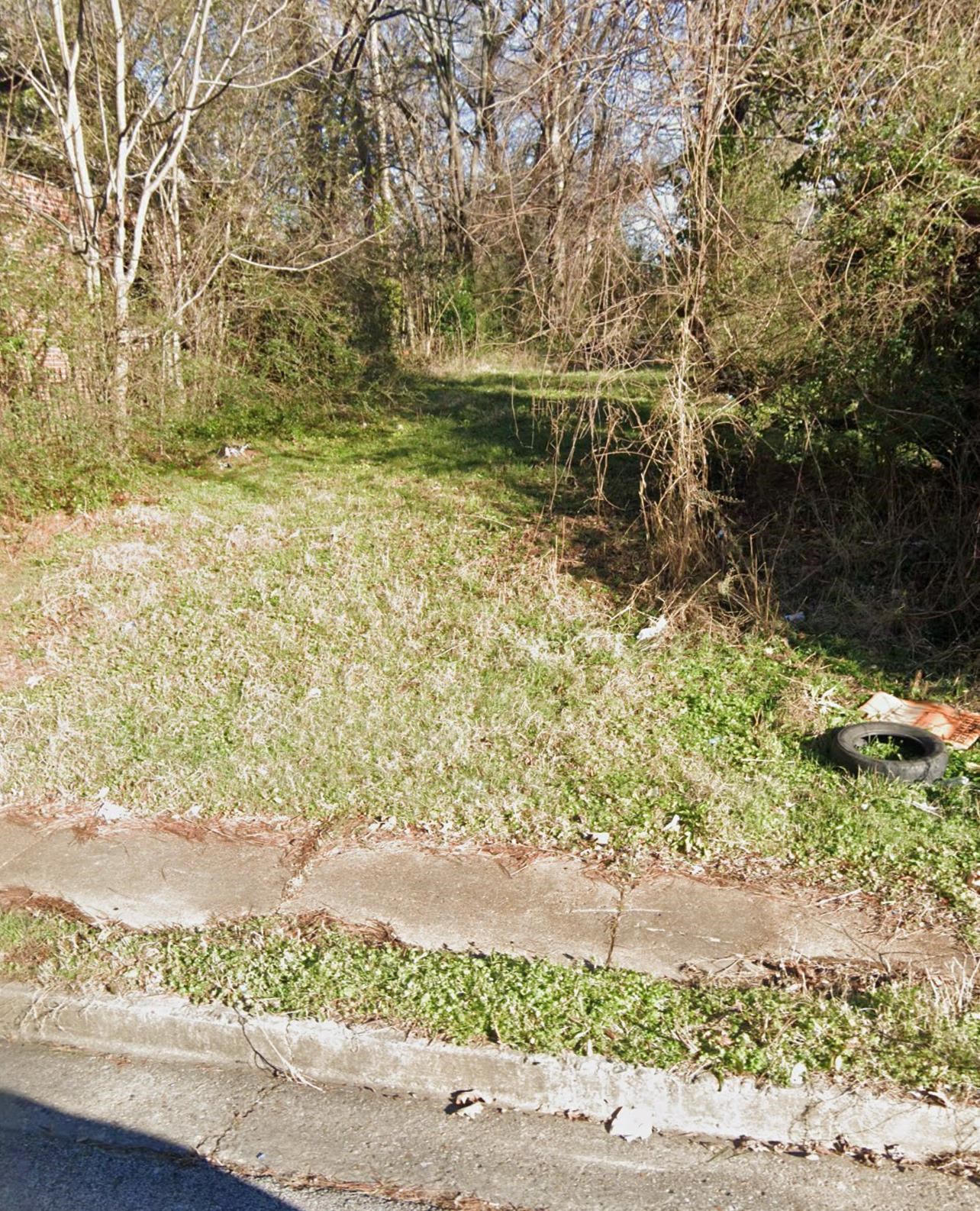 a view of a yard with wooden fence