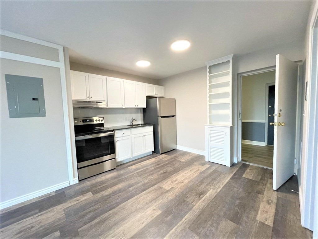 a kitchen with granite countertop a refrigerator and cabinets