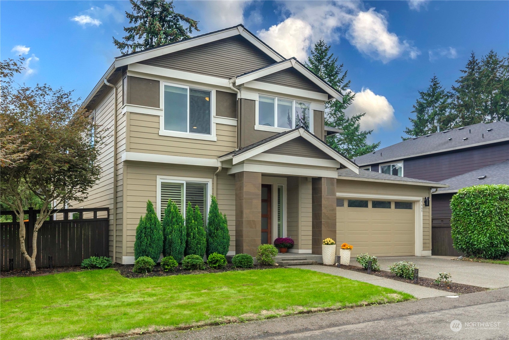 a front view of a house with a yard and plants