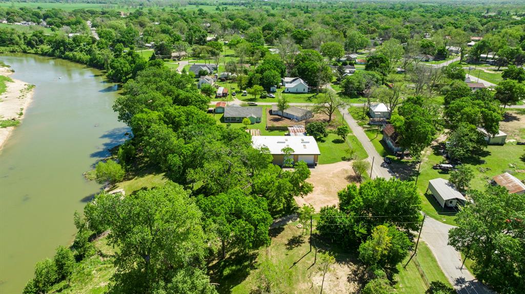 an aerial view of residential house with outdoor space and trees all around