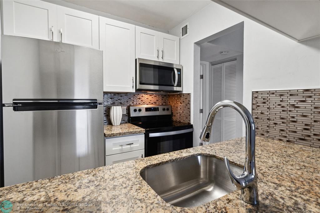 New cabinets, marble counters tile backsplash and stainless appliances