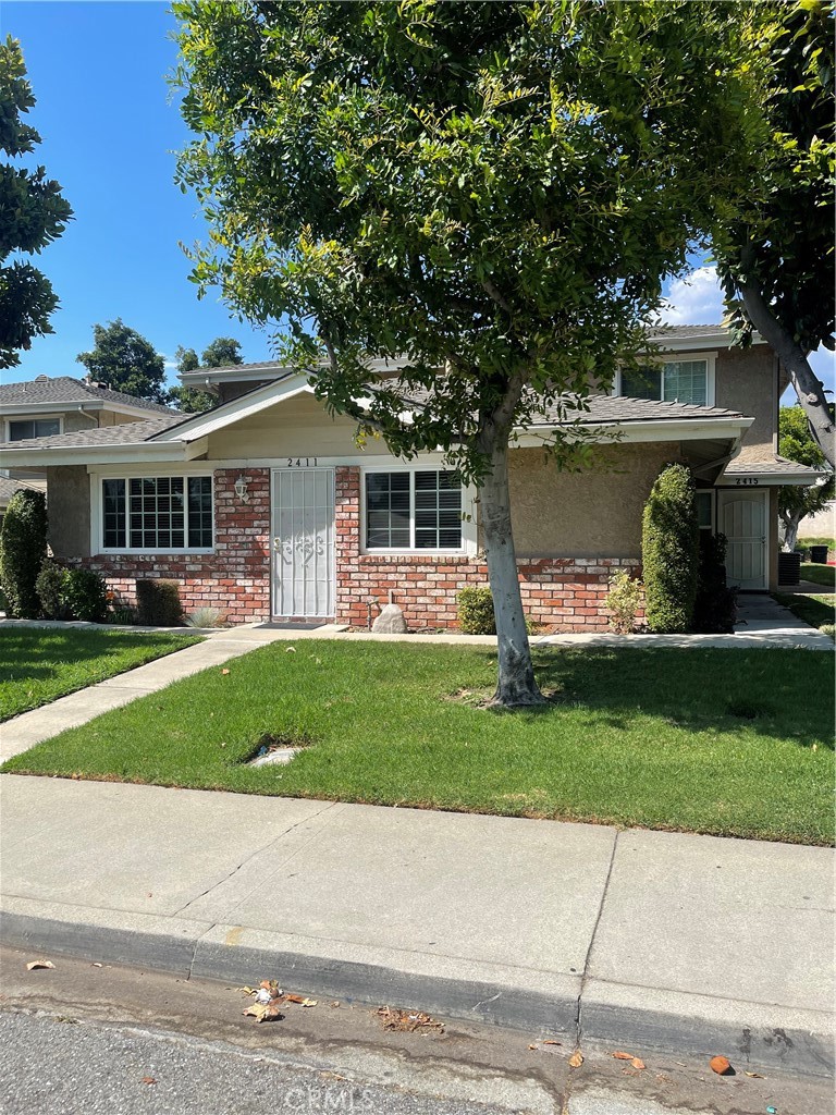 a front view of a house with a garden and trees