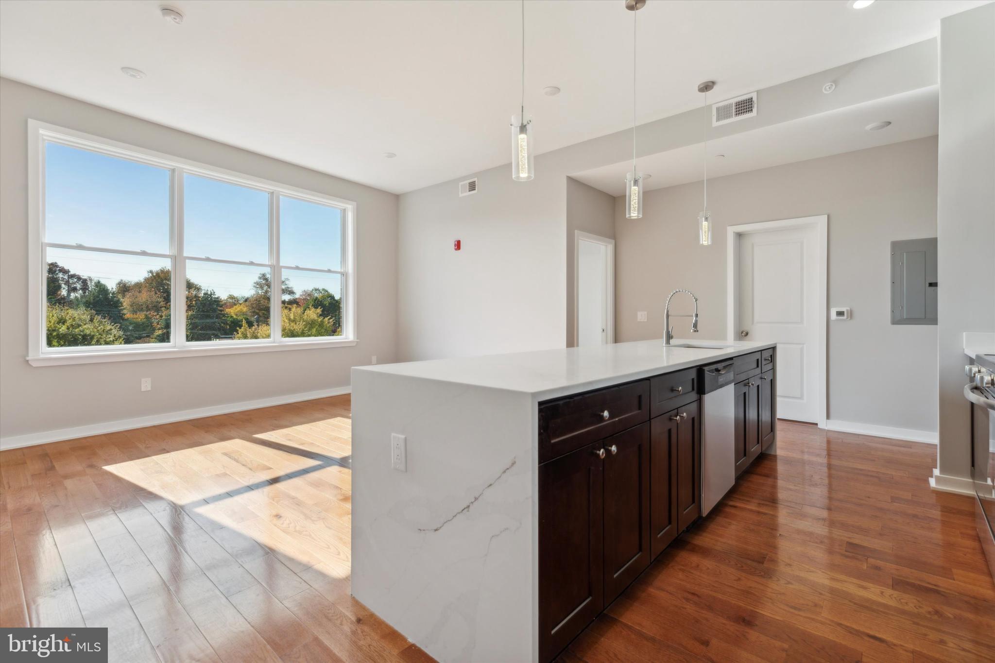 a kitchen with stainless steel appliances a sink cabinets and wooden floor