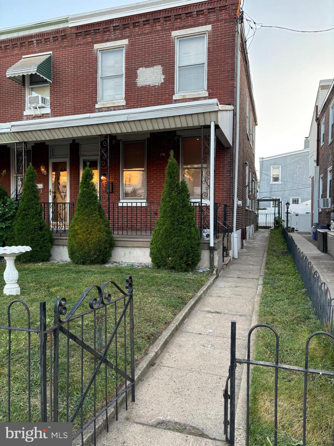 front view of a brick house with a yard