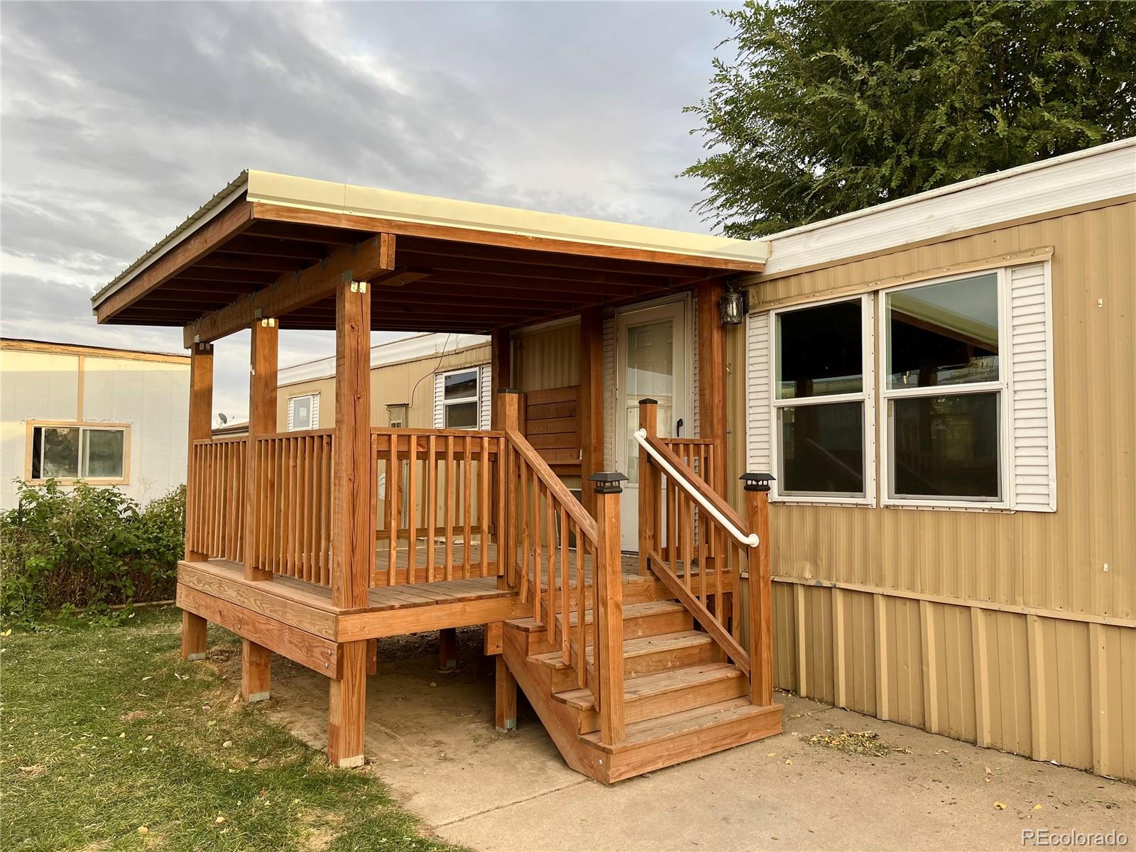 a view of wooden house with a small deck