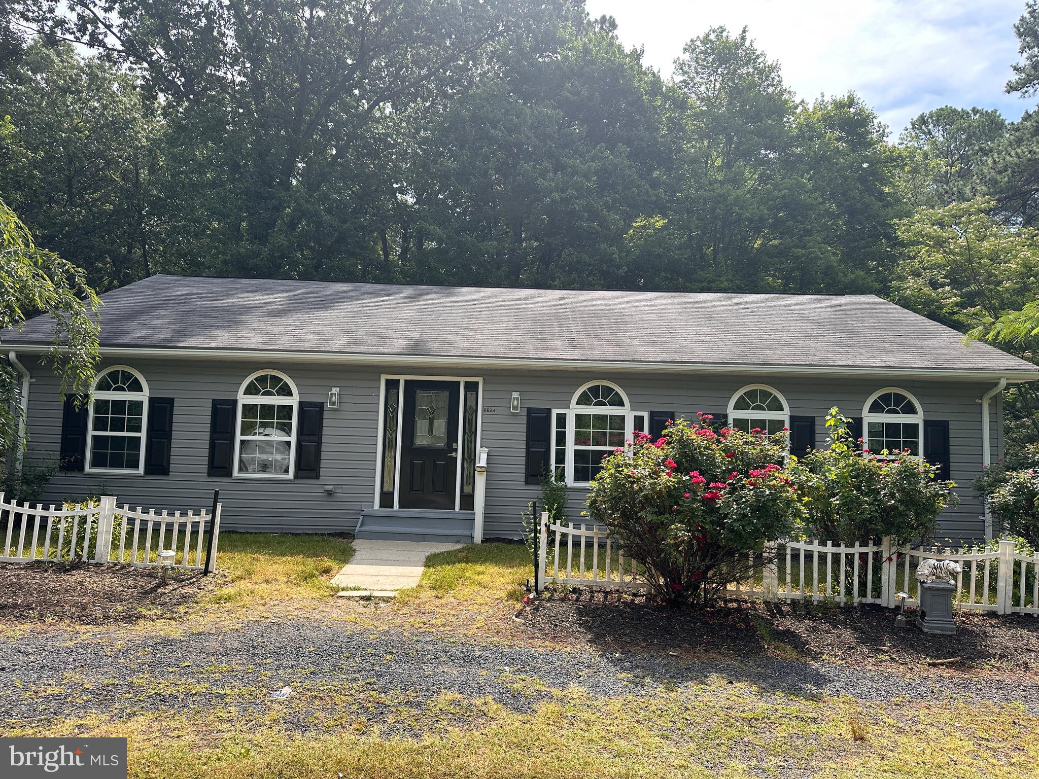 a front view of house with yard space and trees around