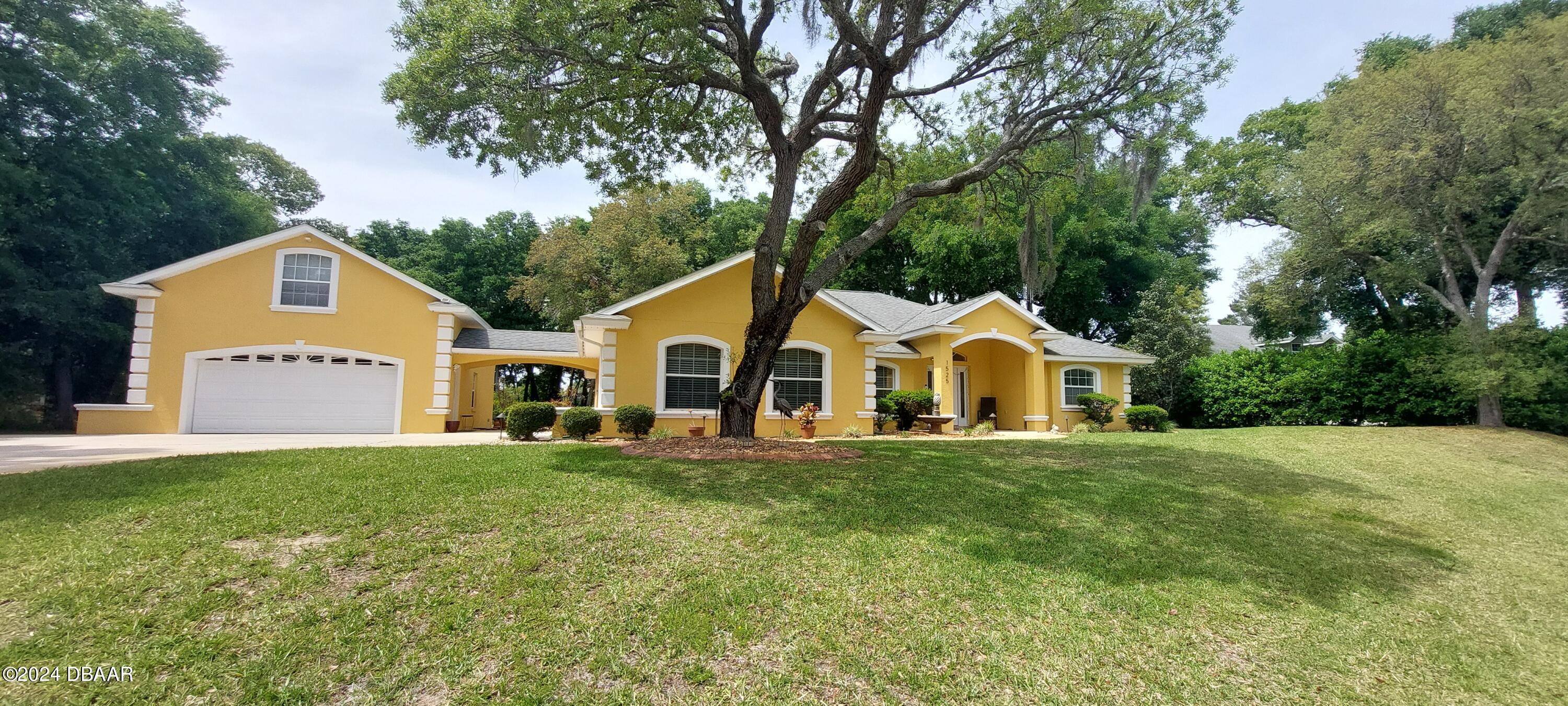 a front view of a house with a yard and trees