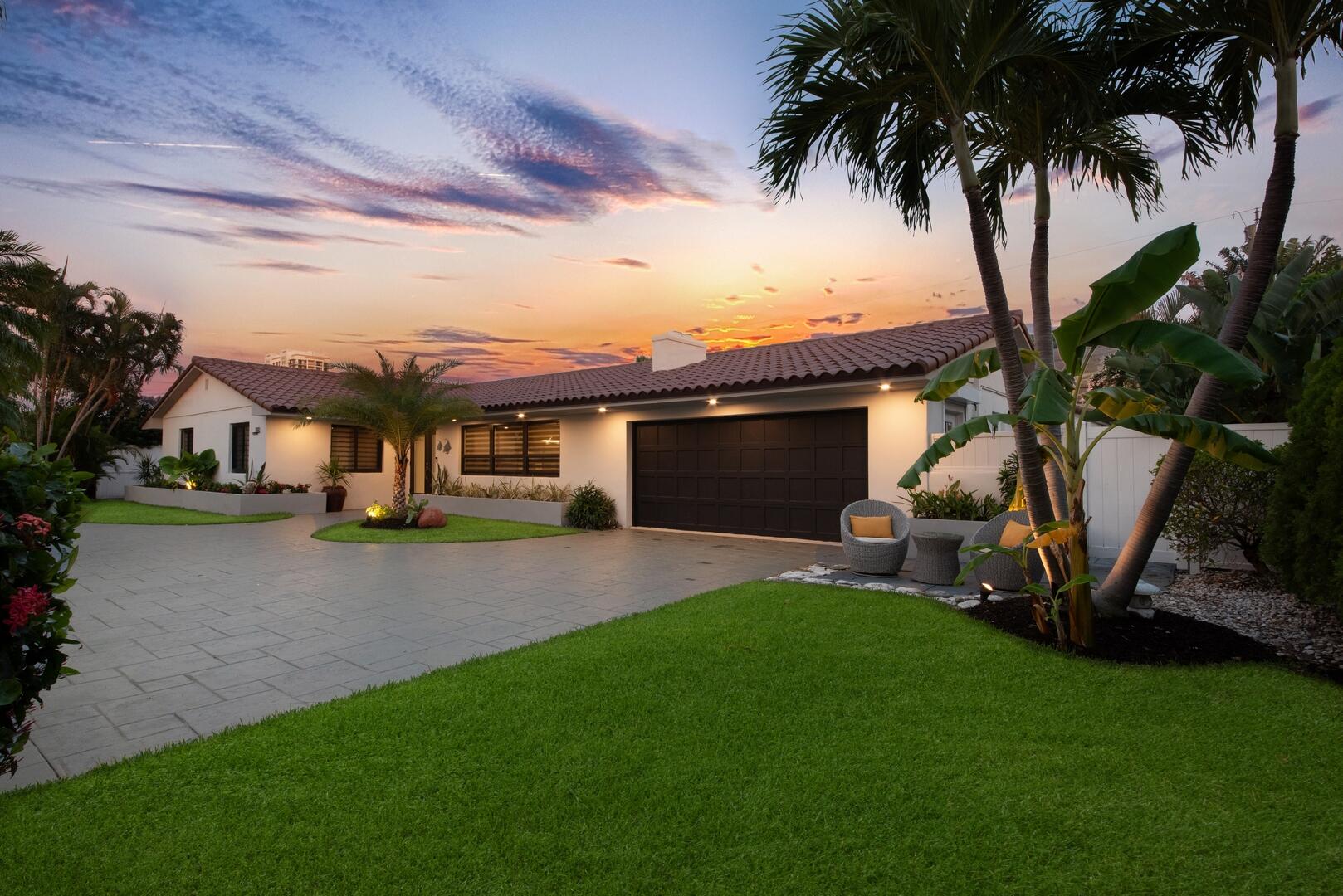 a front view of a house with a garden and yard