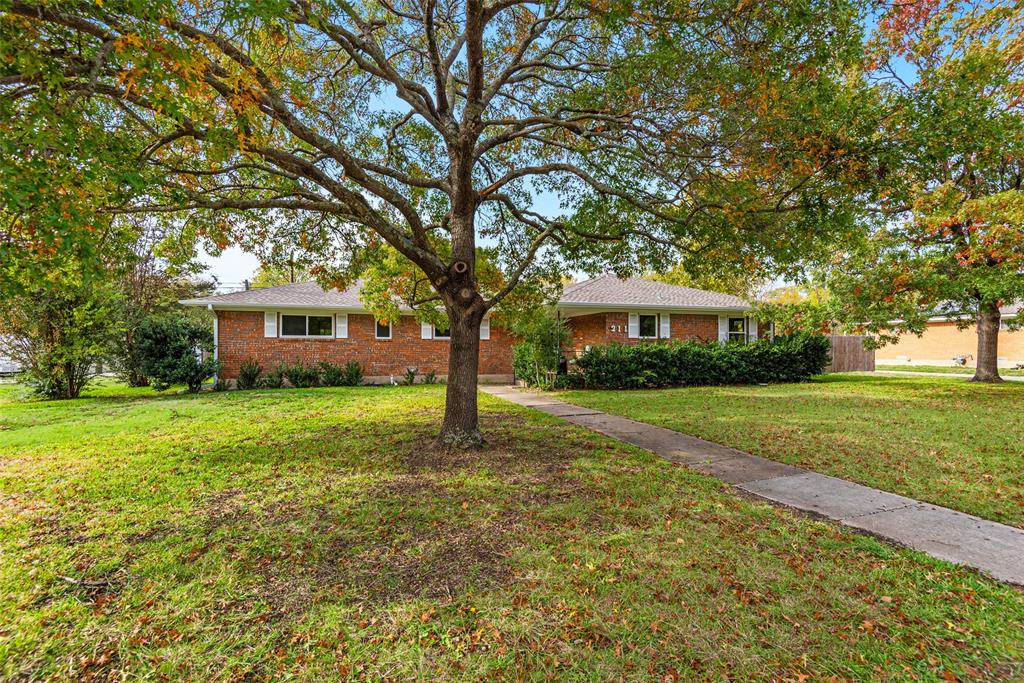 a front view of a house with yard and green space