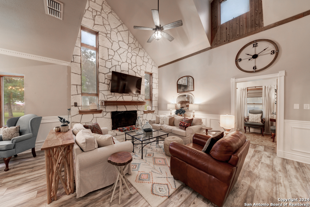 a living room with furniture a fireplace and a flat screen tv